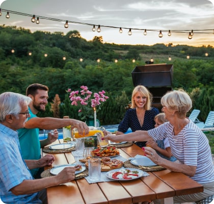 family at a picnic table in a back yard